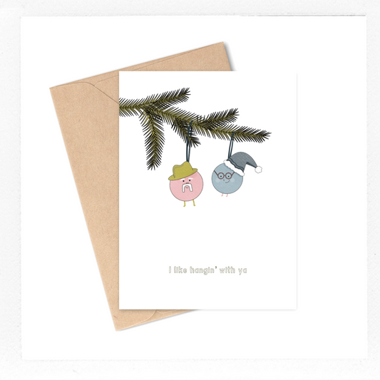 This greeting card features two festive (and adorable) ornaments hanging from a Christmas tree branch and it says "I like hangin with ya". If you and your family have a tradition of putting up the Christmas tree and hanging up the ornaments all together, then this Christmas card will give your loved one the warm fuzzies when they open up that envelope!
