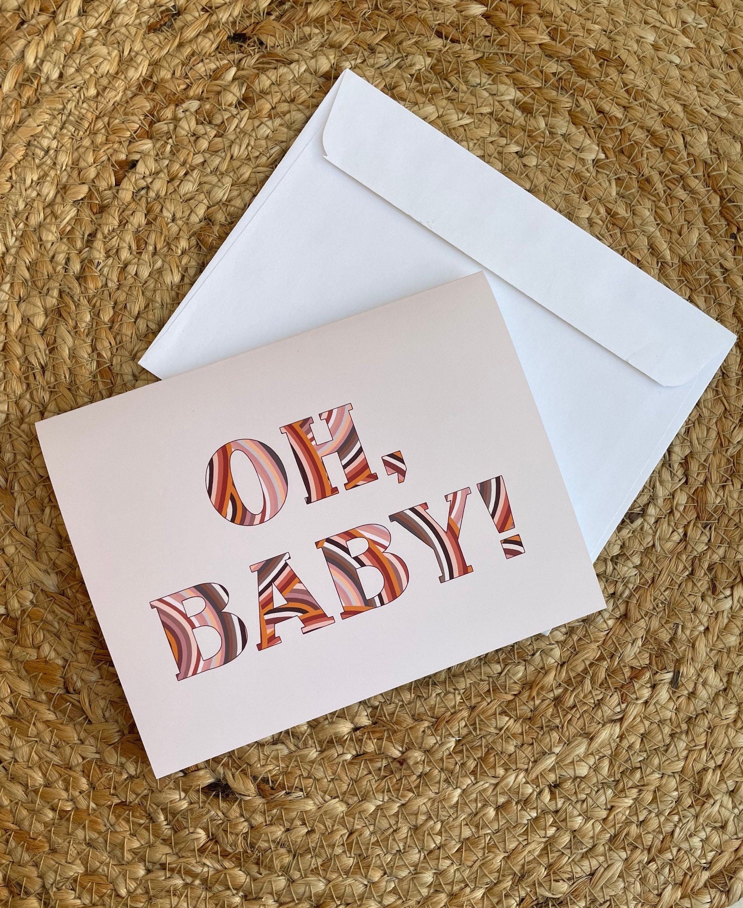 oh baby greeting card with a beige background and an abstract, terra cotta design within the text