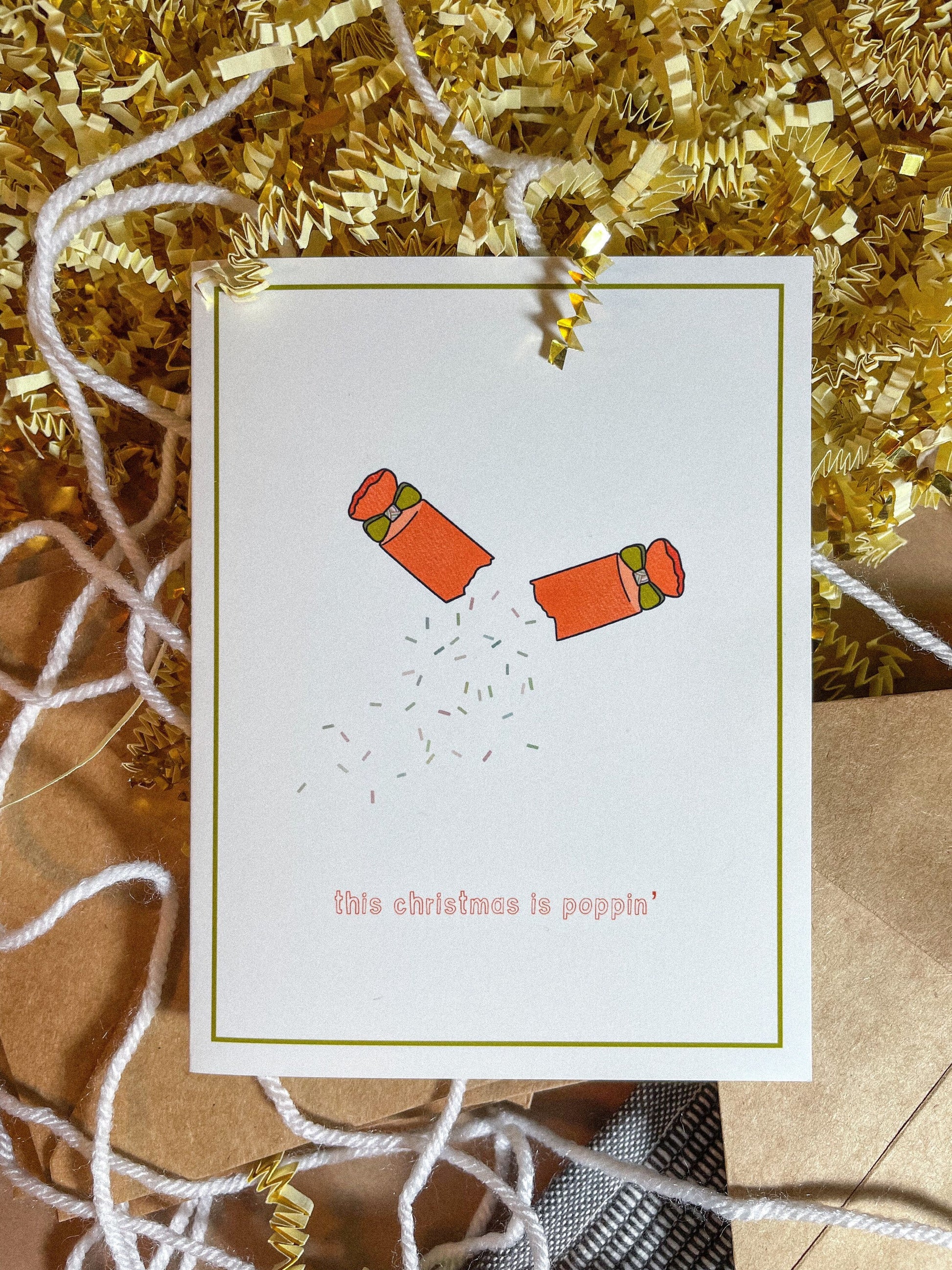 redish orange party popper mid-pop with confetti spilling out and the text this christmas is popppin