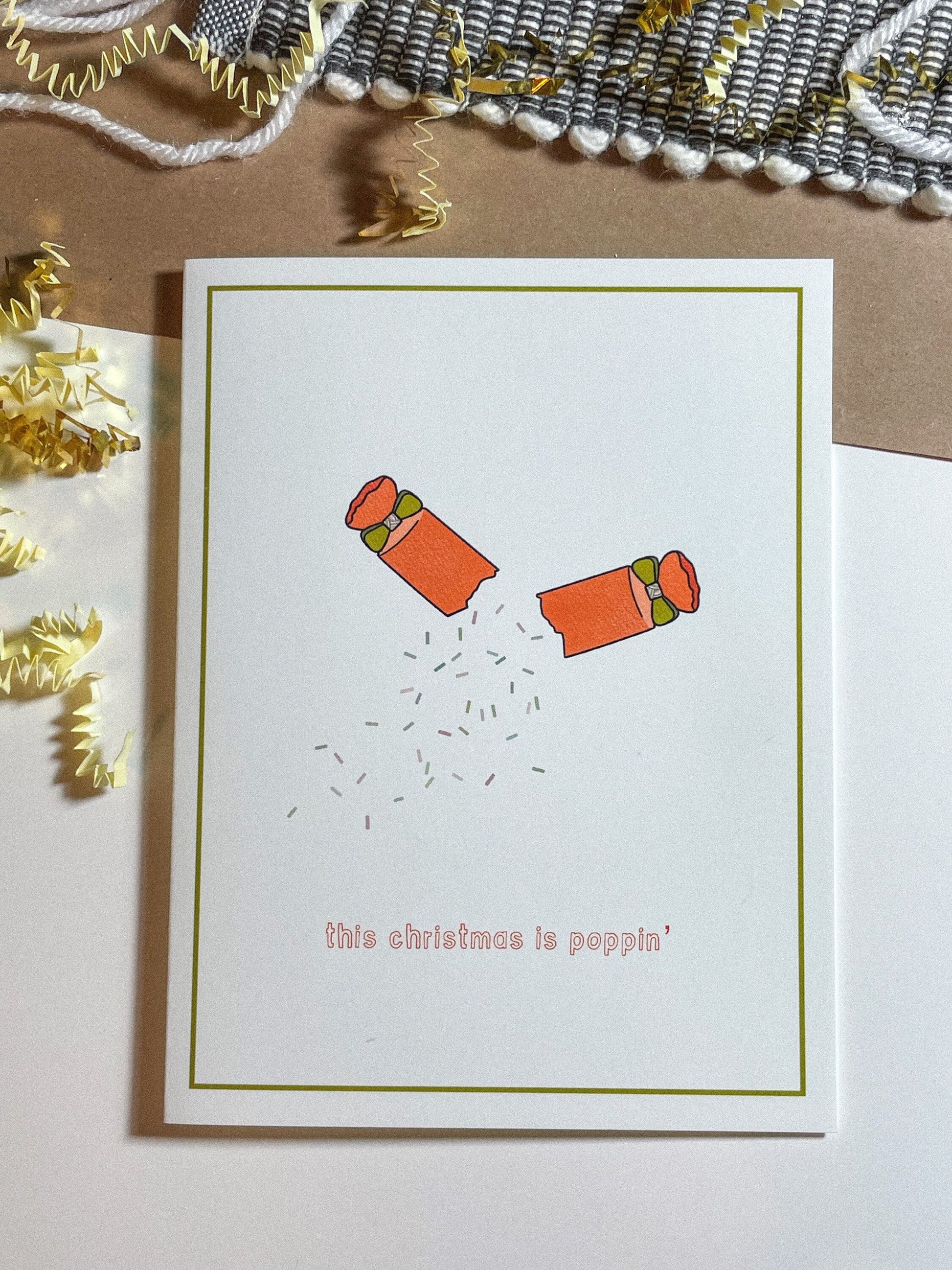 redish orange party popper mid-pop with confetti spilling out and the text this christmas is popppin